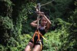 A woman on a zip line in the jungle
